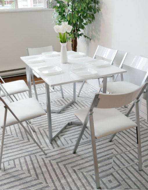 Flip-console-table-in-glossy-white-opened-in-dining-form-with-six-nano-chairs-in-a-modern-room-with-grey-carpet